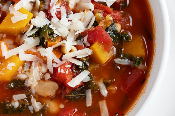Fall minestrone soup in white bowl.