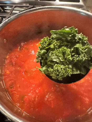 Adding kale to the pot.