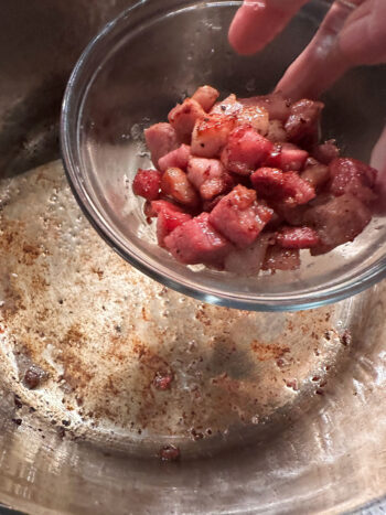 Removing cooked pancetta from the pot.