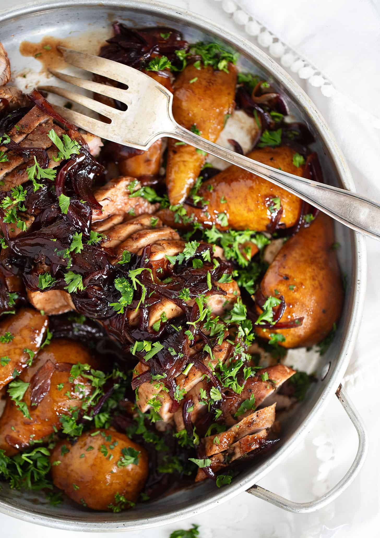 Pork tenderloin with pears in serving dish with fork.