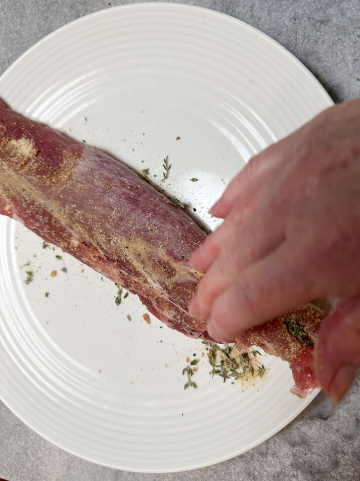 Rubbing spice rub on pork tenderloin/