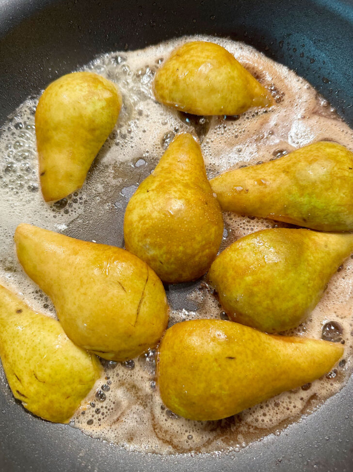 Sautéeing pears in butter in skillet.