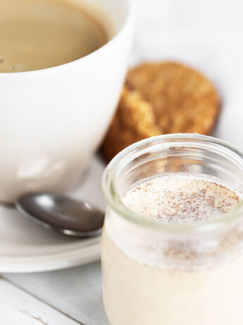 pumpkin spice coffee creamer with cup of coffee behind