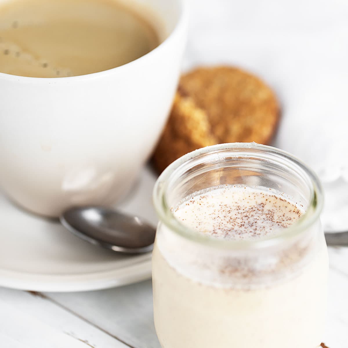 pumpkin spice coffee creamer with cup of coffee behind