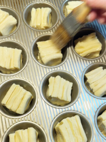cut rolls in muffin tin and brushing with butter