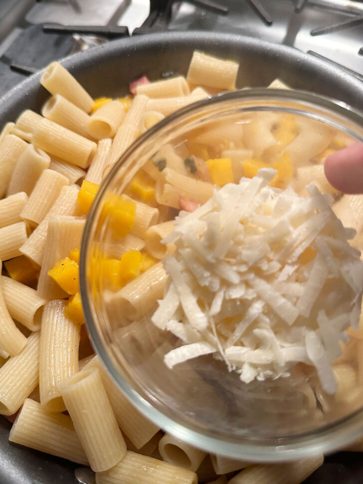 adding pecorino cheese to pasta