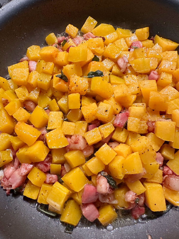 adding roasted butternut squash to skillet