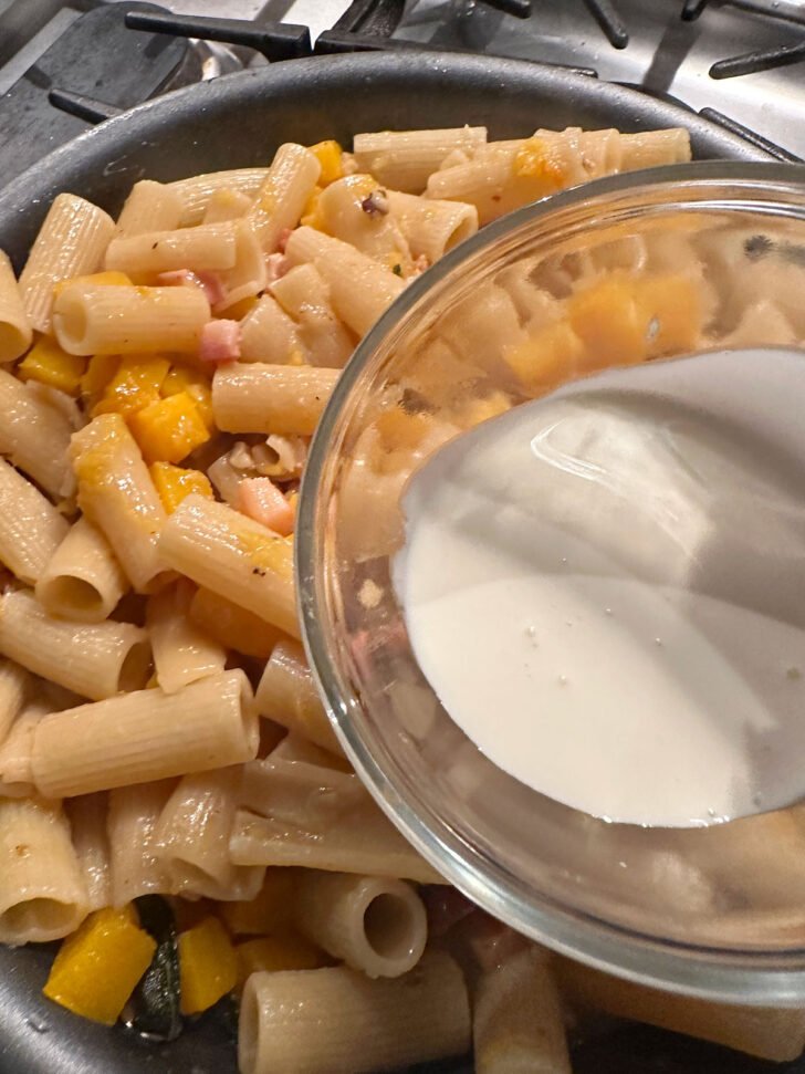 adding cream to pasta to finish