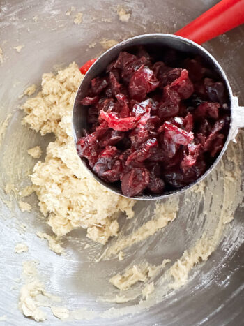 adding dried cranberries to dough