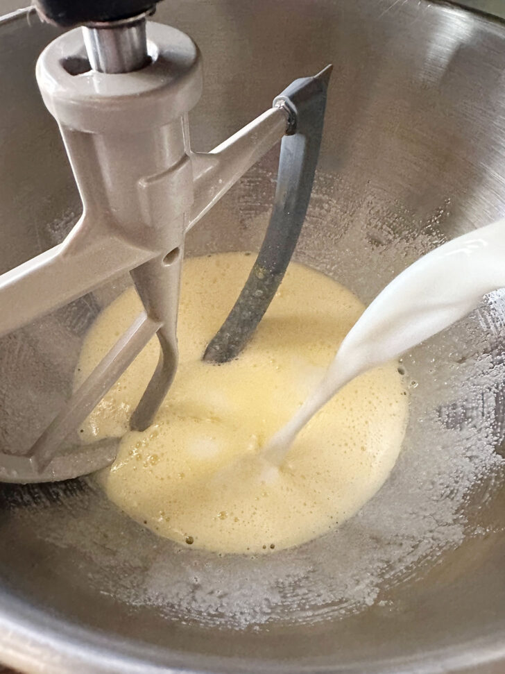 adding milk to beaten eggs and sugar