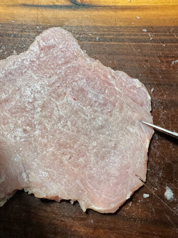 cutting small slits in the side of the pork