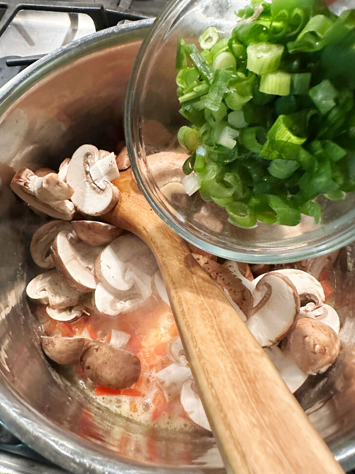 sauteing red pepper, mushrooms and green onion in pan