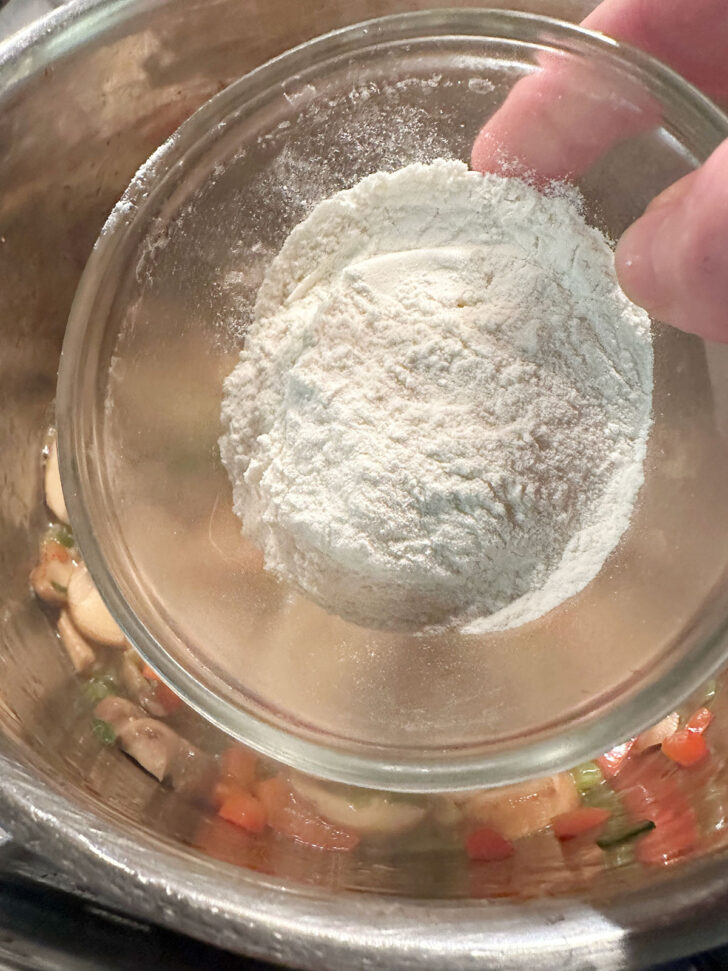 adding flour to the vegetables