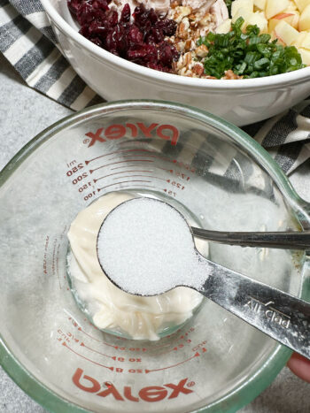 adding sugar to dressing in measuring cup