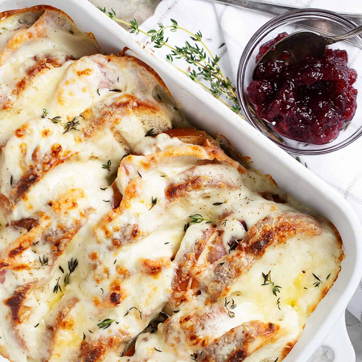Croque Monsieur casserole in baking dish with cranberry sauce on the side