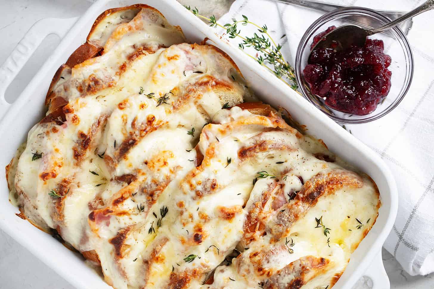 Croque Monsieur casserole in baking dish with cranberry sauce on the side