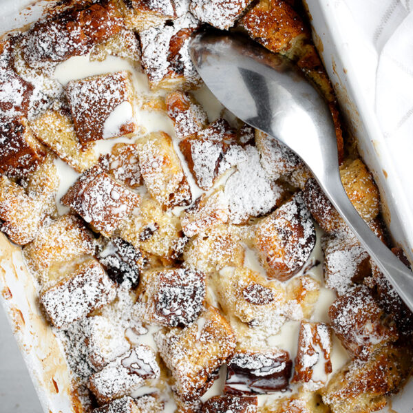 eggnog bread pudding in baking dish with spoon