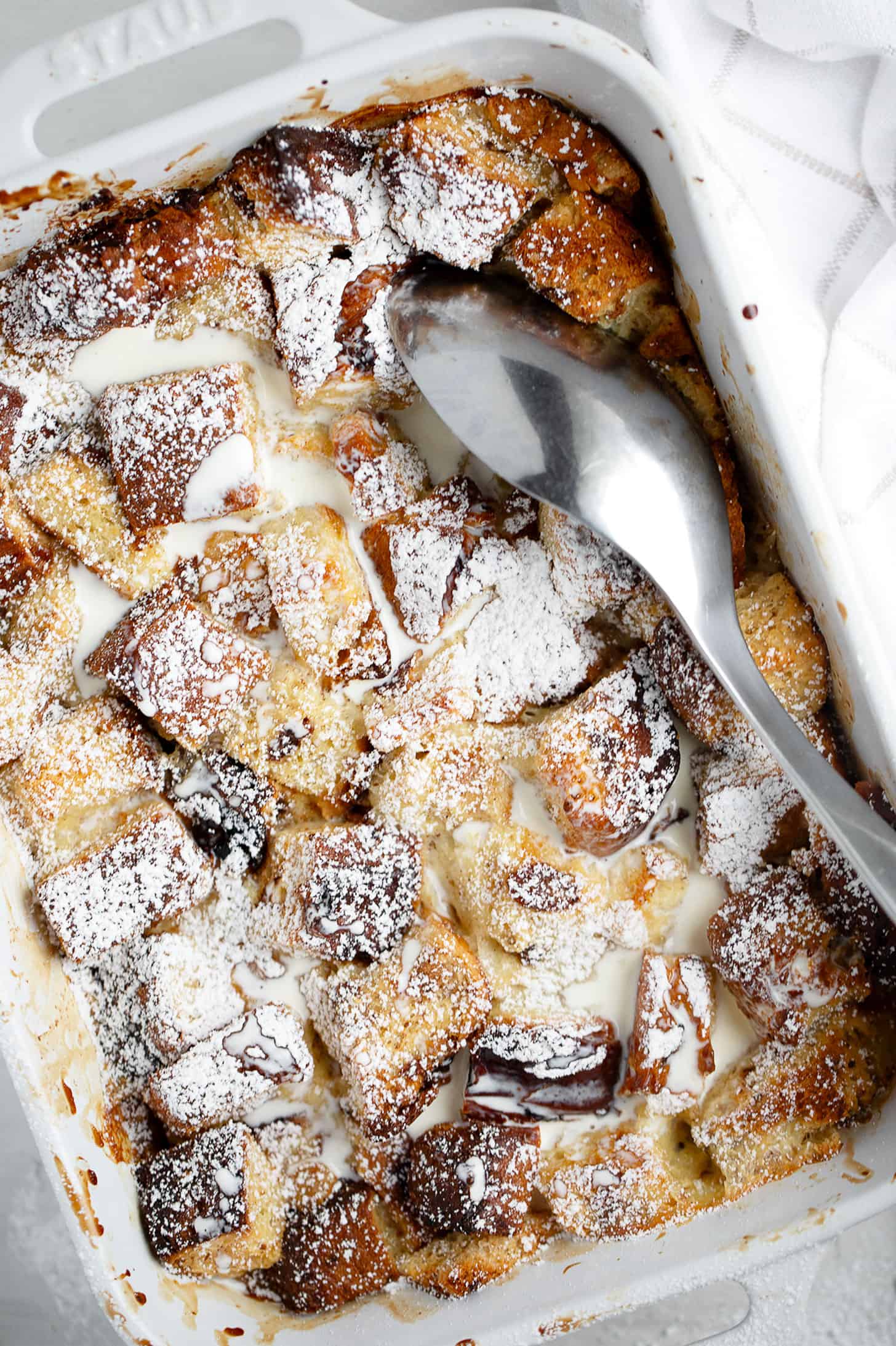 eggnog bread pudding in baking dish with spoon