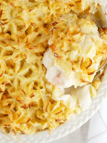 Fish pie in baking dish with spoon