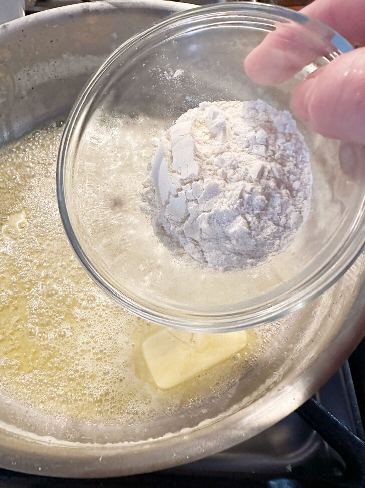 adding flour to melted butter in skillet