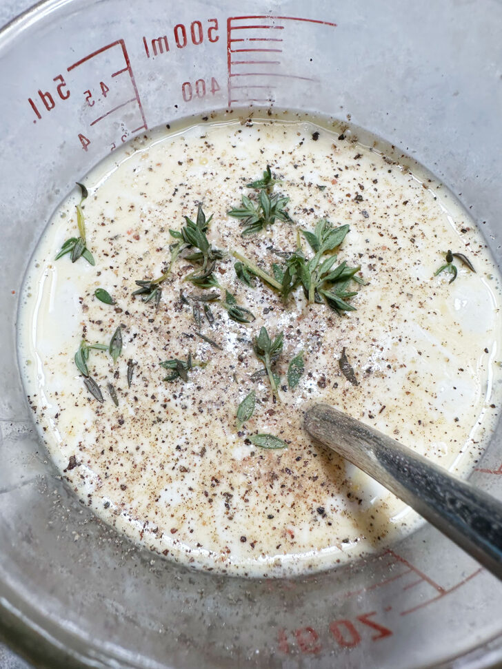 adding seasoning and thyme to egg and cream mixture