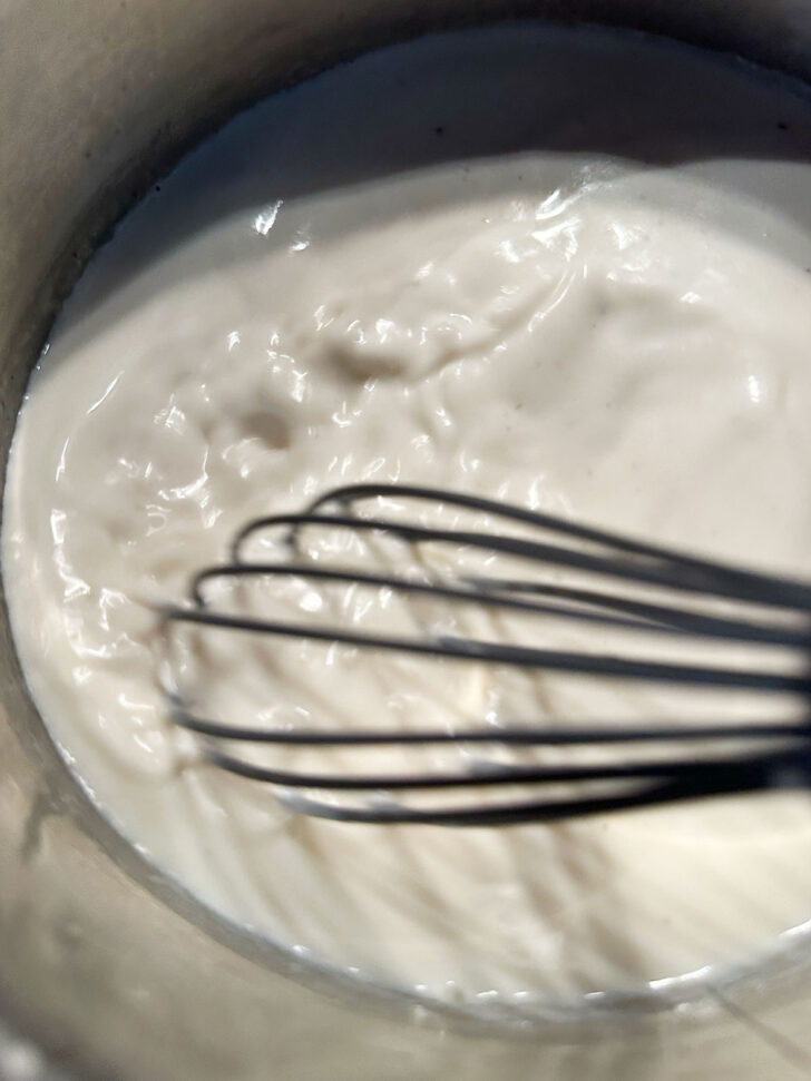 whisking milk in saucepan