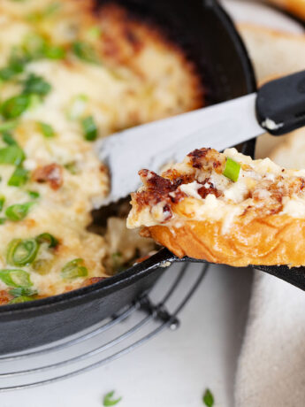 Hot onion dip in cast iron skillet with bread
