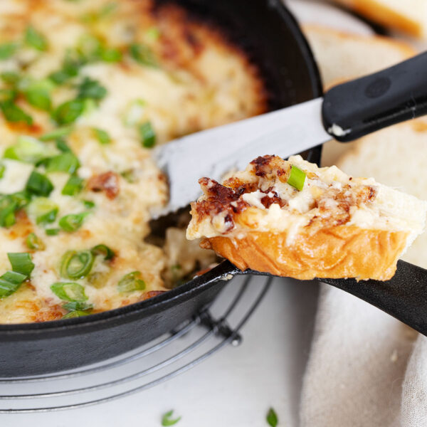 Hot onion dip in cast iron skillet with bread