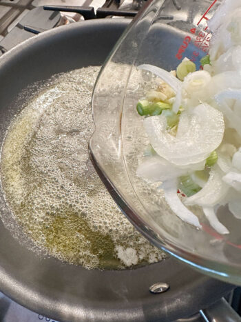 adding onions and garlic to skillet with melted butter