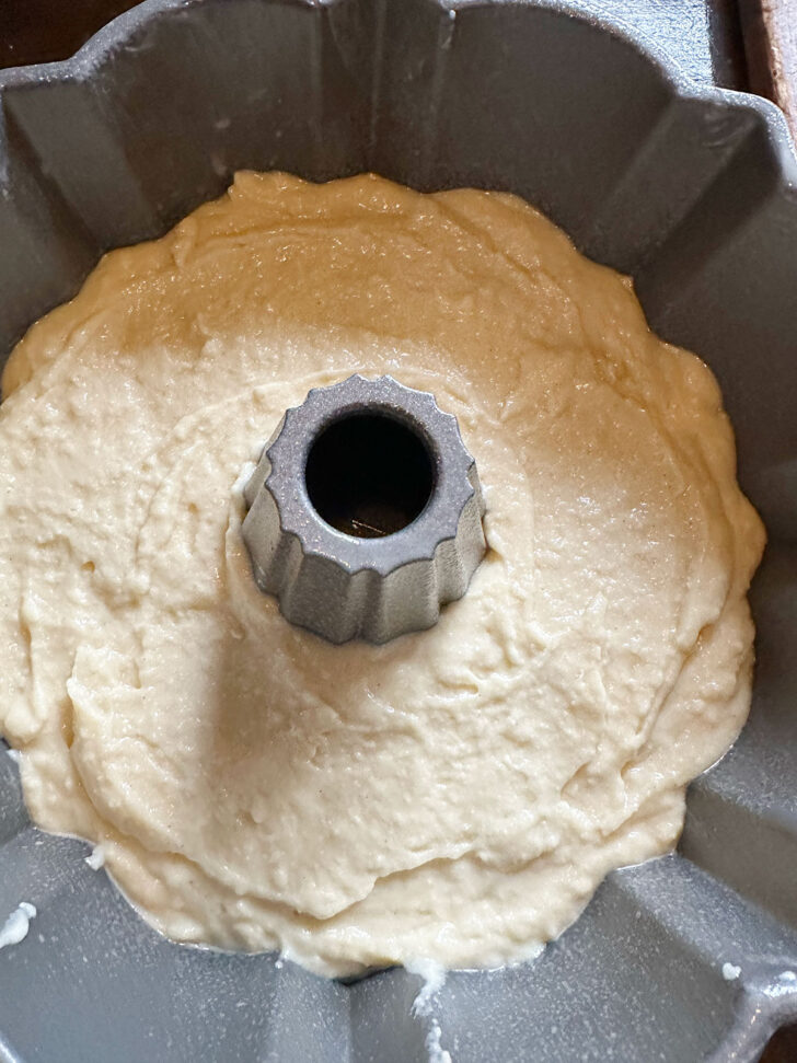 Half of the batter added to a bundt pan.