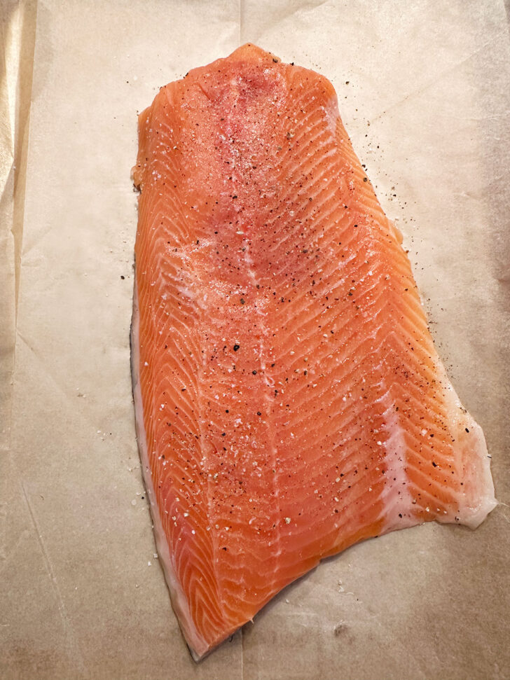 salmon fillet on parchment-lined baking sheet before cooking