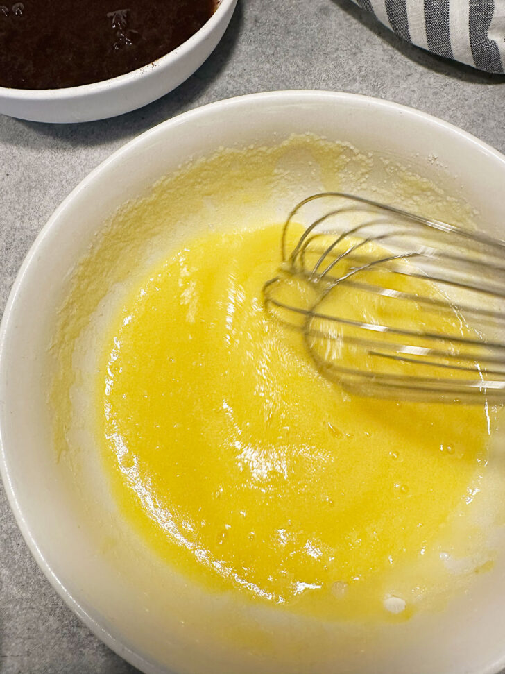 Eggs and sugar whisked together in bowl.