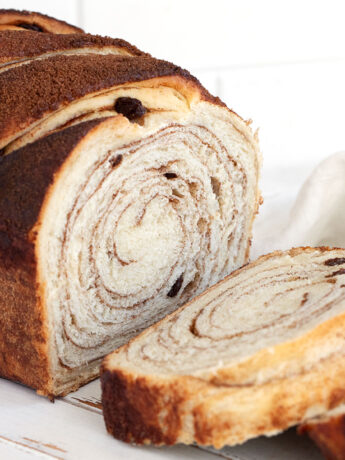 Cinnamon raisin bread sliced on cutting board.