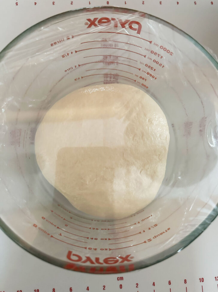 Dough set to rise in a covered bowl.