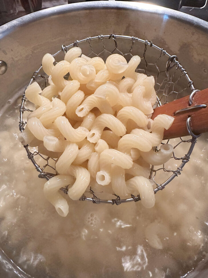 Draining cooked pasta.