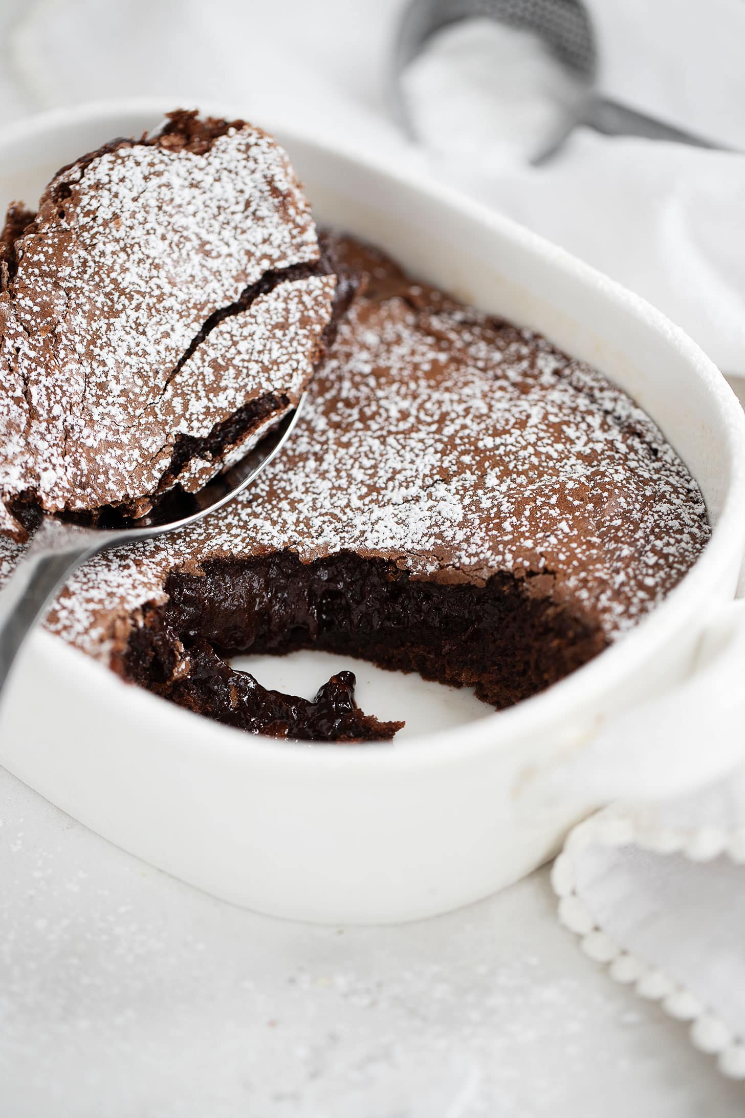 Chocolate brownie cake in baking dish with spoon.