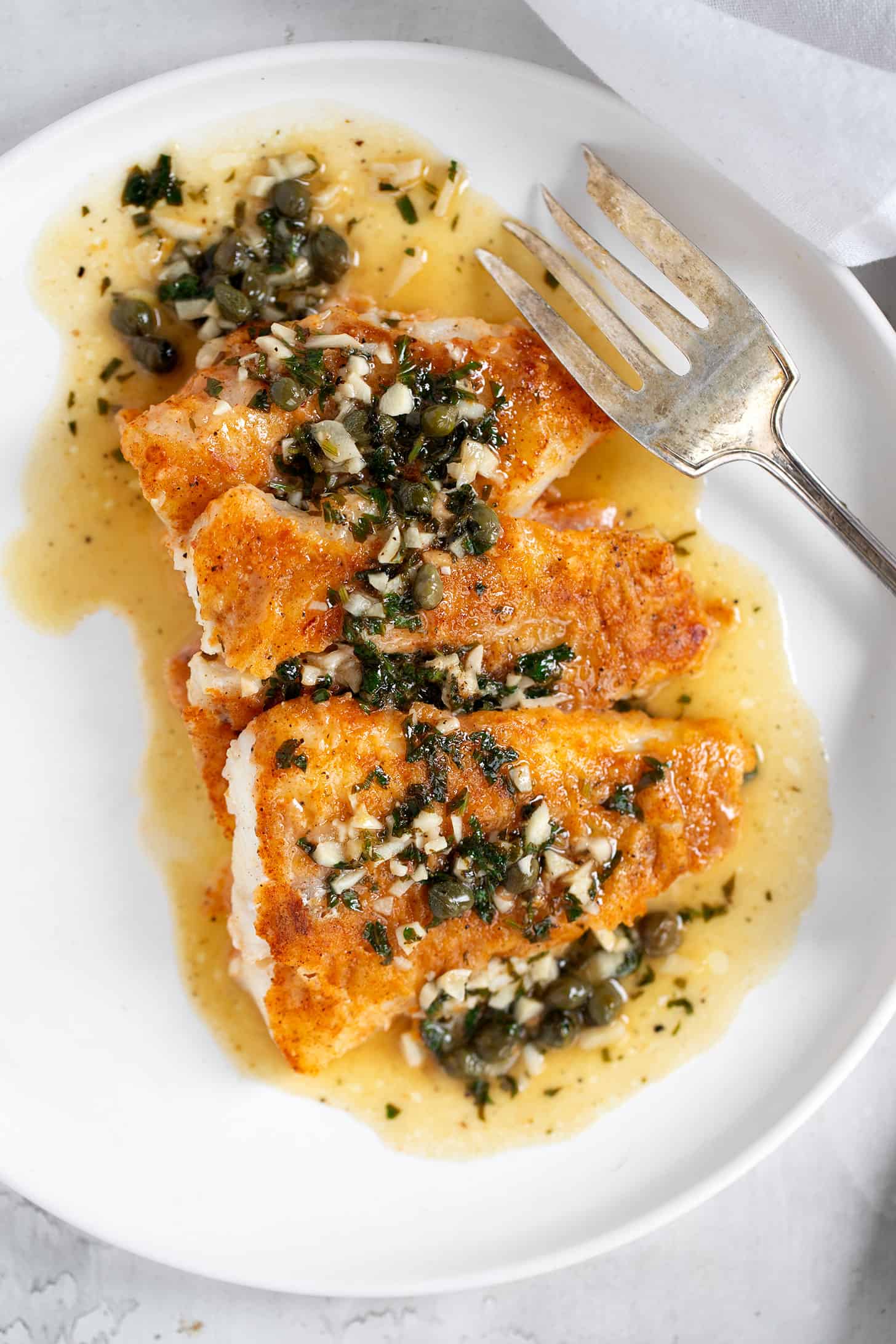 Cod Piccata on plate with fork.