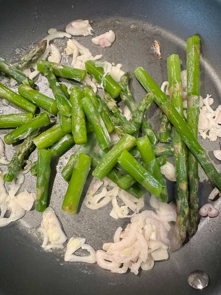 Shallots and asparagus in a skillet.