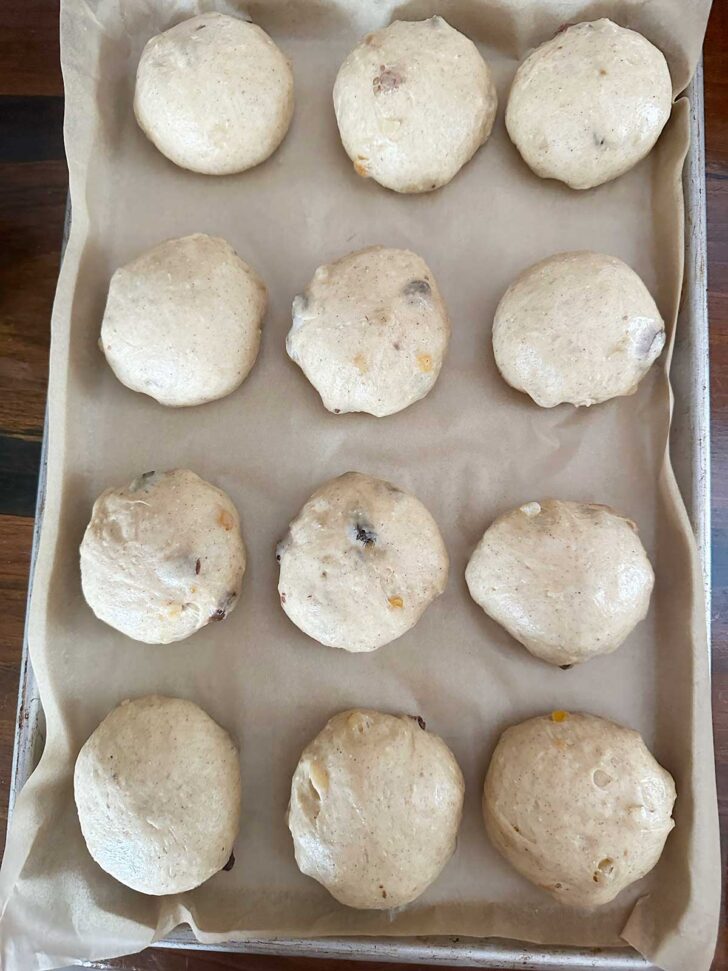 12 dough balls on a parchment-lined baking sheet.