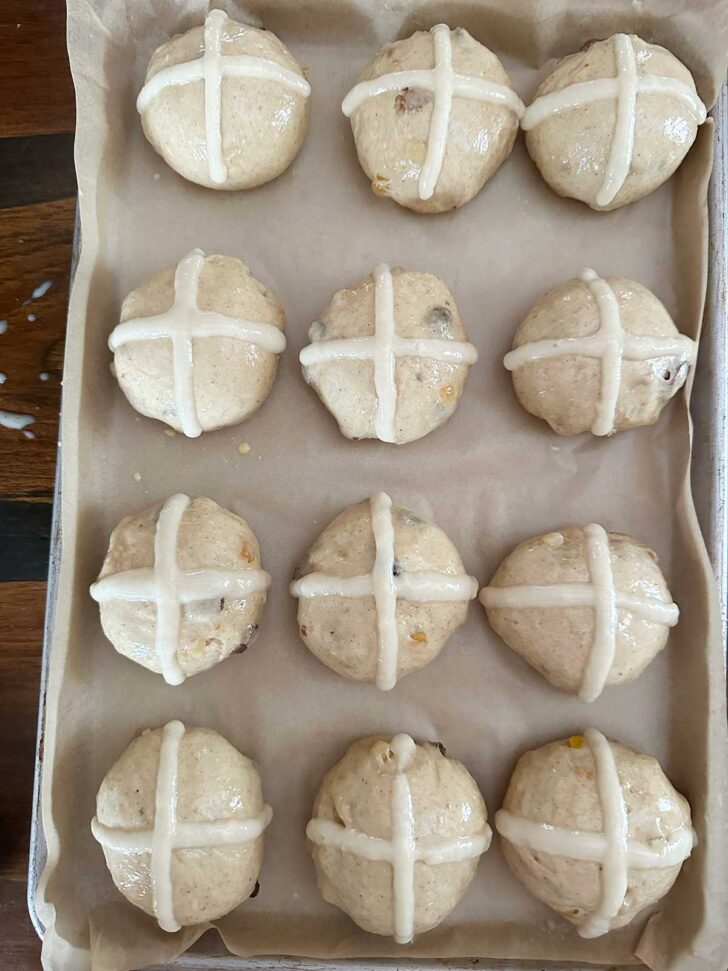 Buns after piping the flour crosses on top.