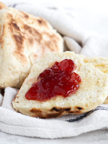 Irish soda farls on tea towel split with jam.