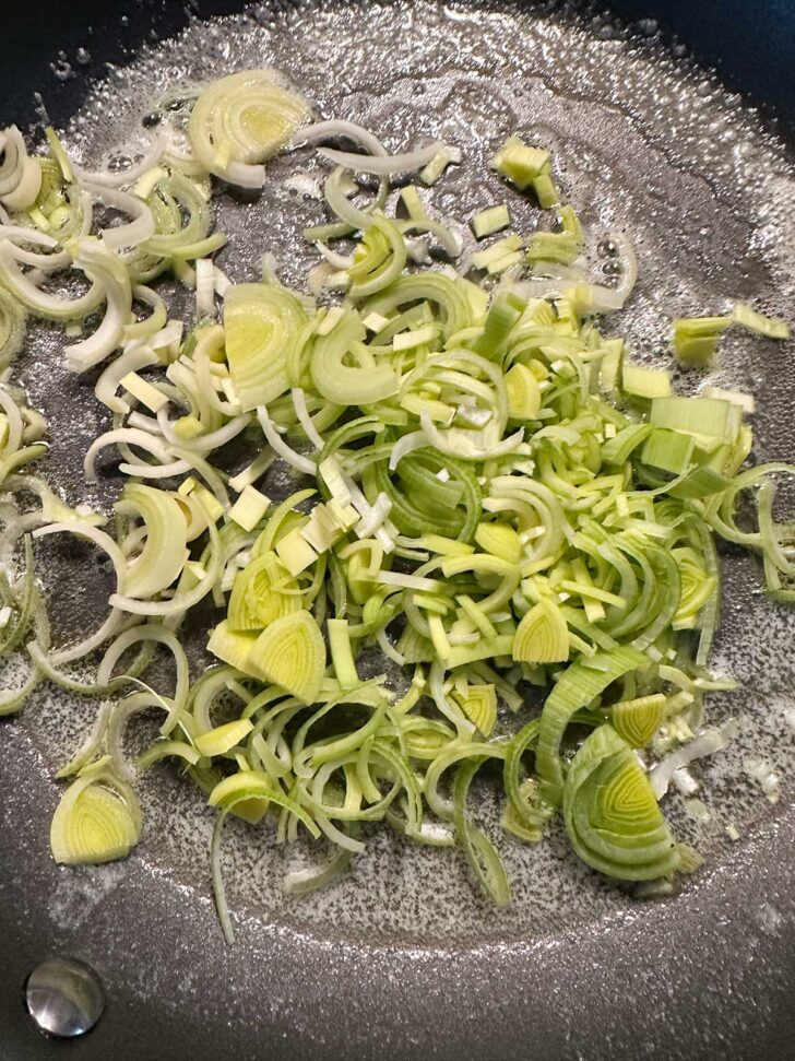 Chopped leeks added to skillet with melted butter.