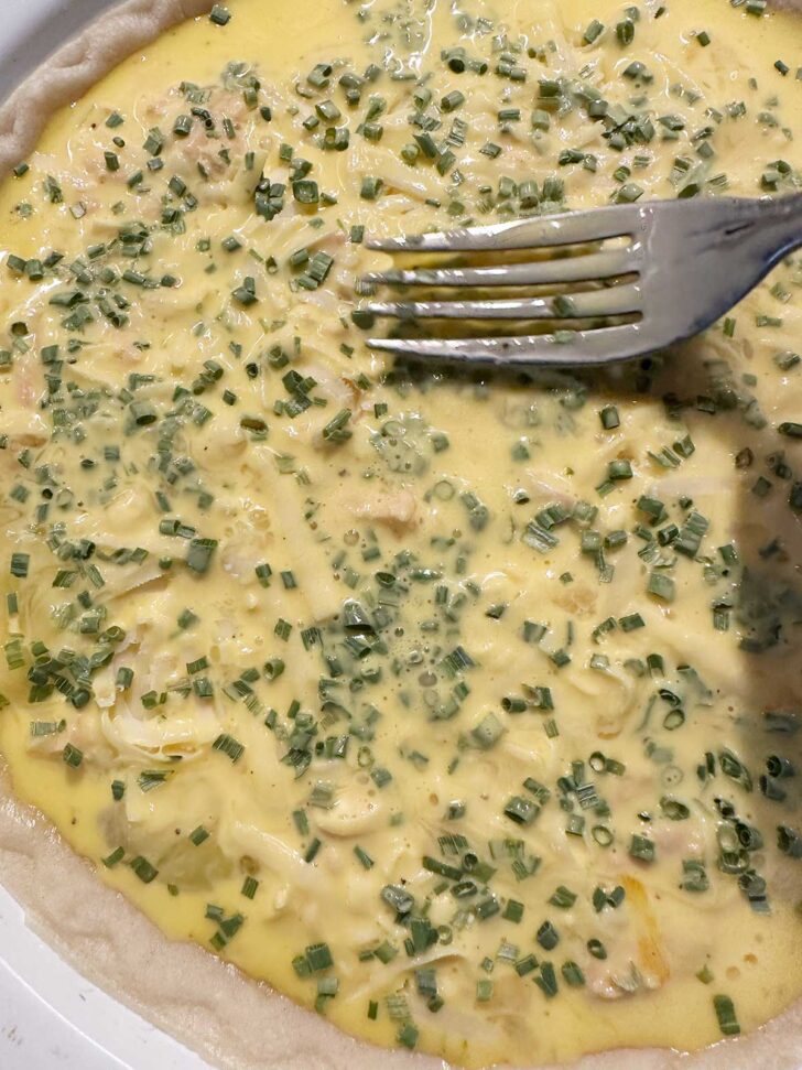 Using a fork to press chives into custard.