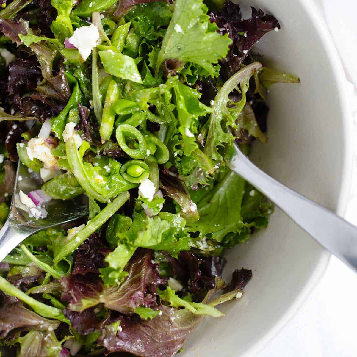 Chopped Spring salad with asparagus and snap peas in bowl.