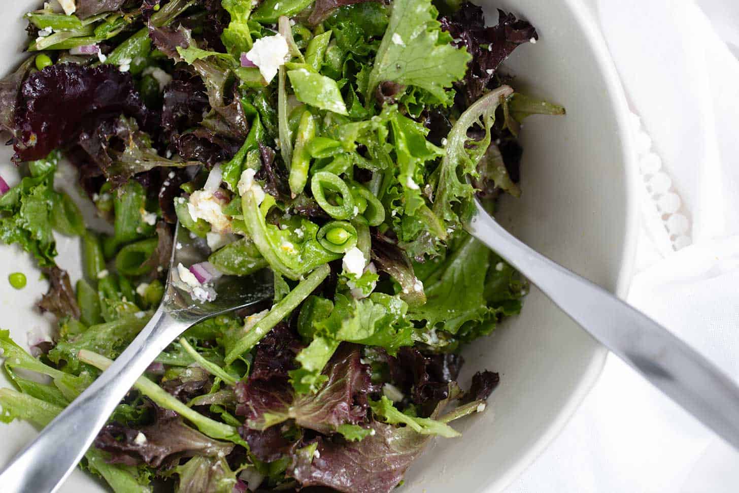 Chopped Spring salad with asparagus and snap peas in bowl.