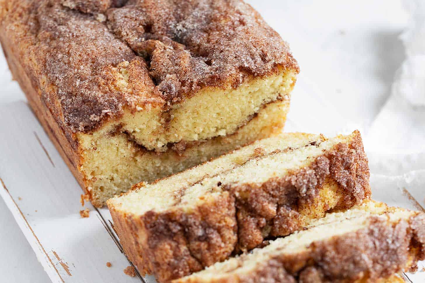 Cinnamon and sugar bread sliced on cutting board.