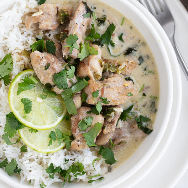 Creamy coconut lime chicken in a bowl over rice.