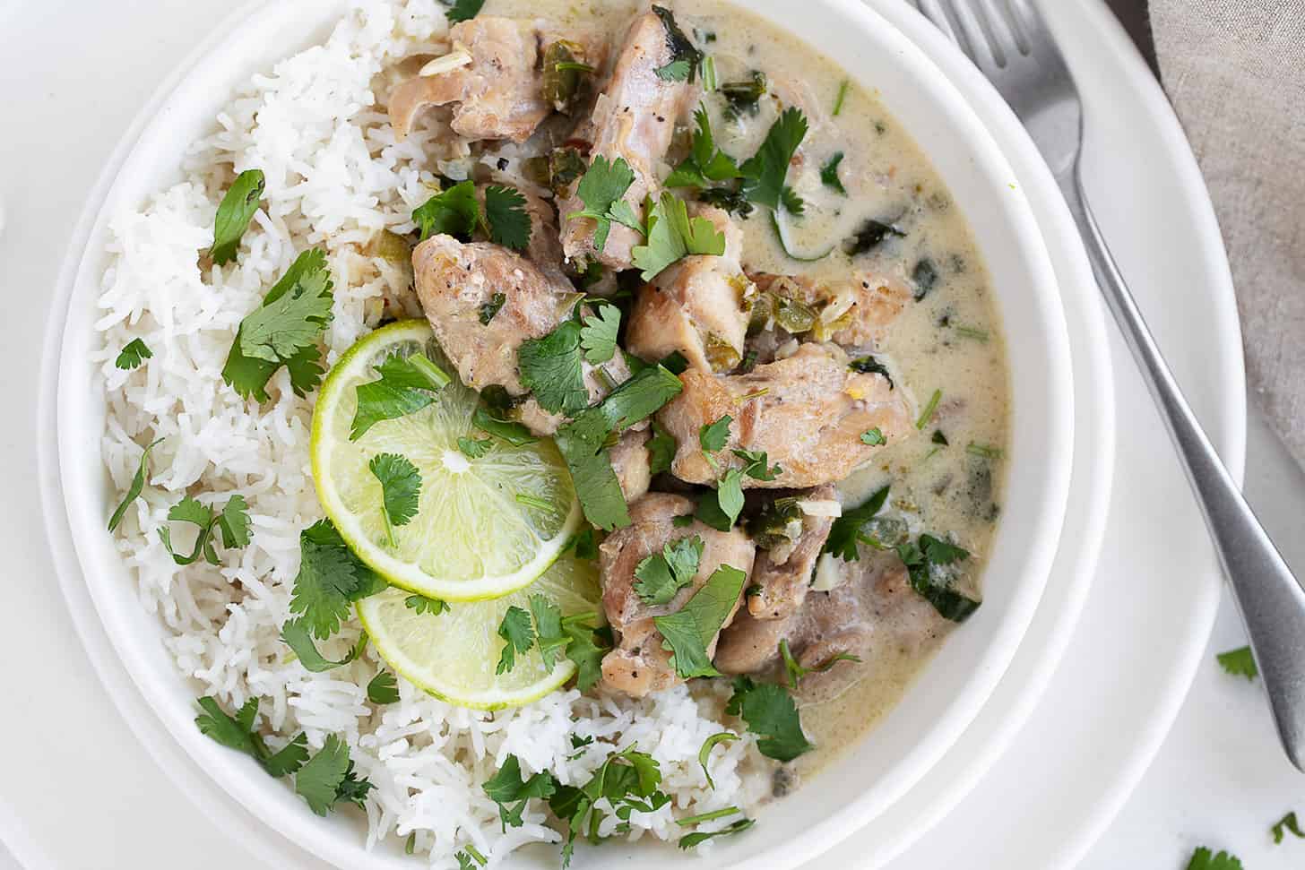 Creamy coconut lime chicken in a bowl over rice.