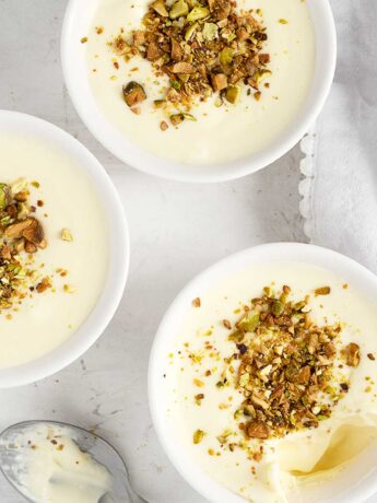 Lemon curd pudding in ramekins with pistachios on top.