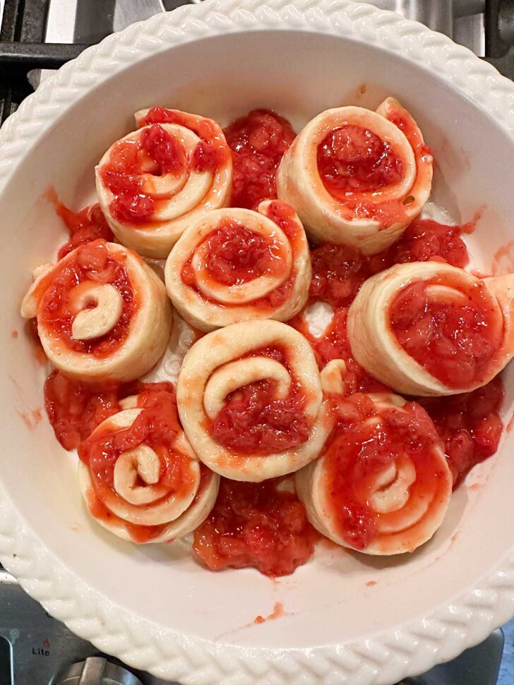 Rolls and extra strawberry mixture in baking pan.